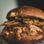 Close-up of a delicious pulled pork sandwich on a plate.